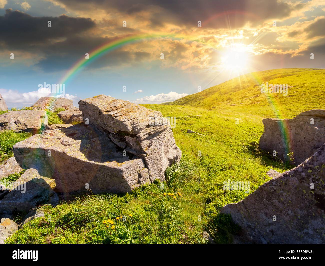 sunset over Carpathian mountain summer landscape. meadow with huge stones among the grass on top of the hillside near the peak of mountain range. alpi Stock Photo