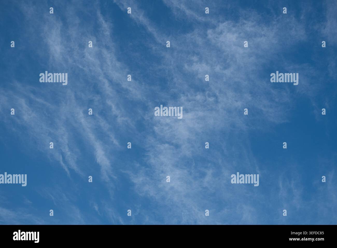 Thin cirrus clouds form a textured pattern across a clear blue sky. Stock Photo