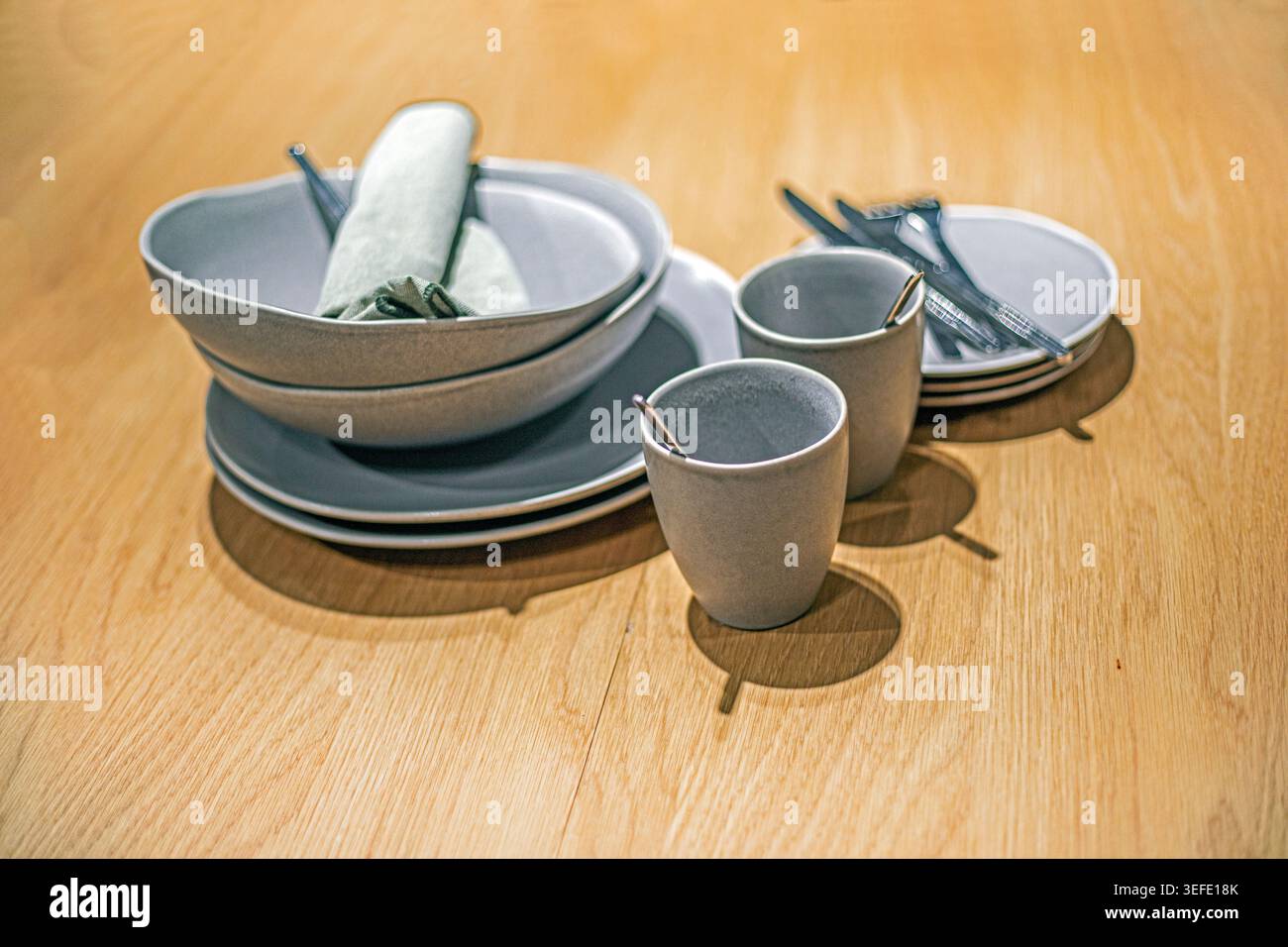 A stylish gray ceramic dinnerware set on the counter Stock Photo