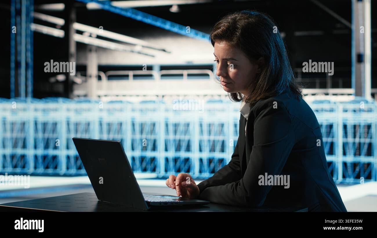 Optimizing server, laptop and software developer in data center doing load balancing. Adjusting system parameters, notebook and woman in server farm at desk improving efficiency Stock Photo