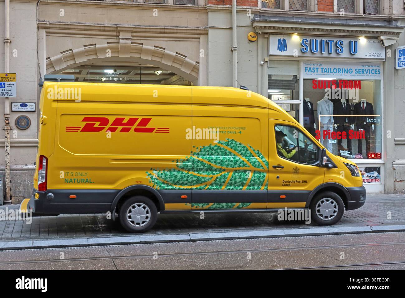 Yellow electric DHL delivery van on a Birmingham city-centre street, West Midlands, England, UK. Stock Photo