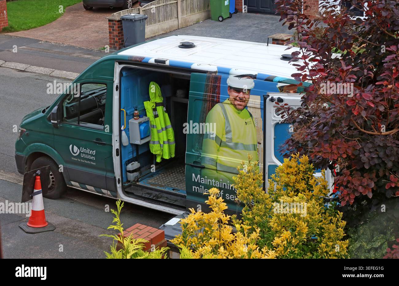 United Utilities worker and van maintaining sewers on a residential street in Grappenhall, Warrington, Cheshire. Stock Photo