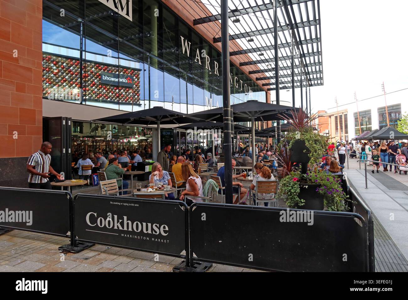 Busy summer dining at Cookhouse Warrington Market, showing packed outdoor seating in the Time Square leisure quarter. Stock Photo