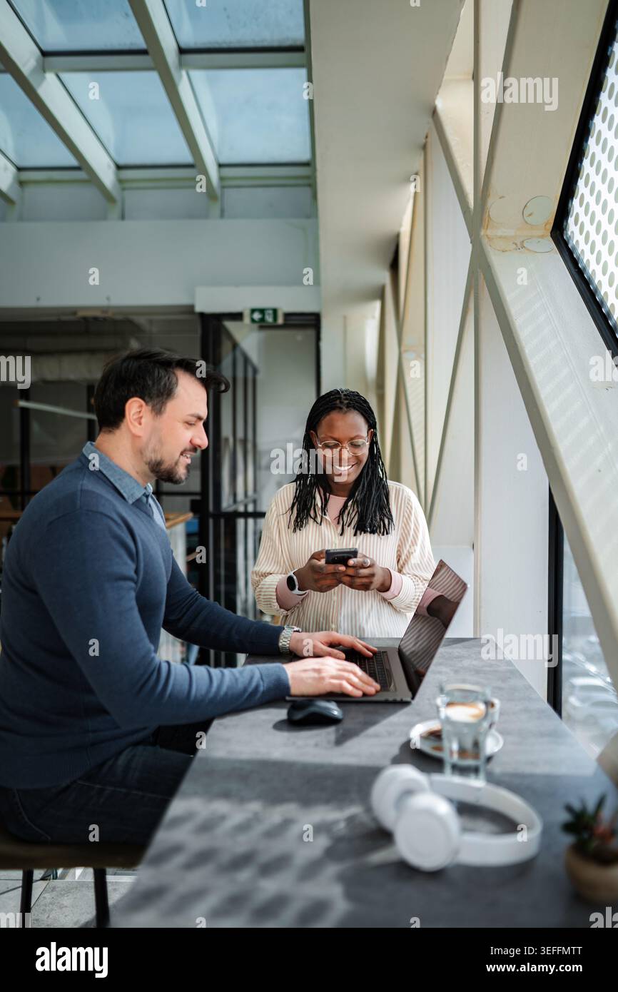 Diverse business professionals collaborating on work using technology Stock Photo