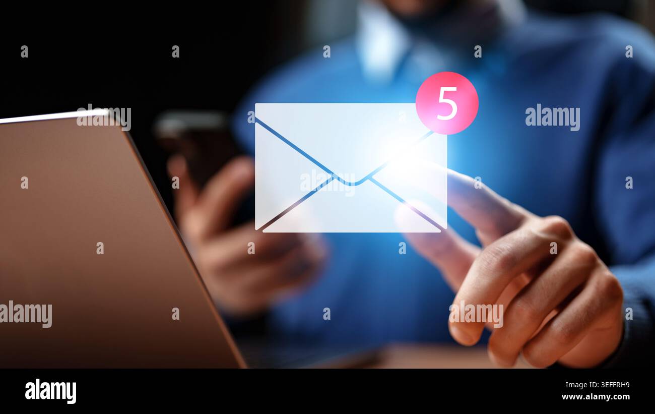 Checking email notifications on a computer and smartphone while working from home Stock Photo