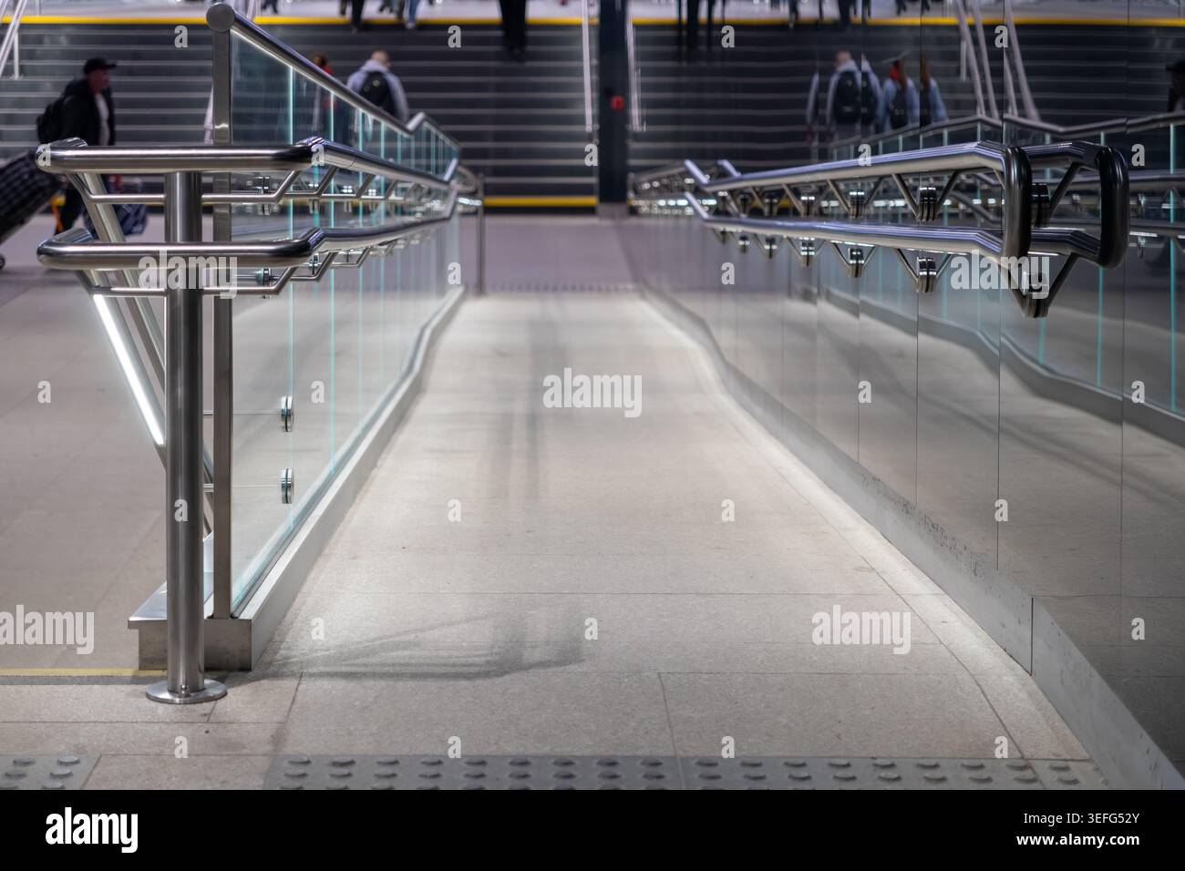 A close view of a sleek indoor ramp featuring glass panels and metal ...