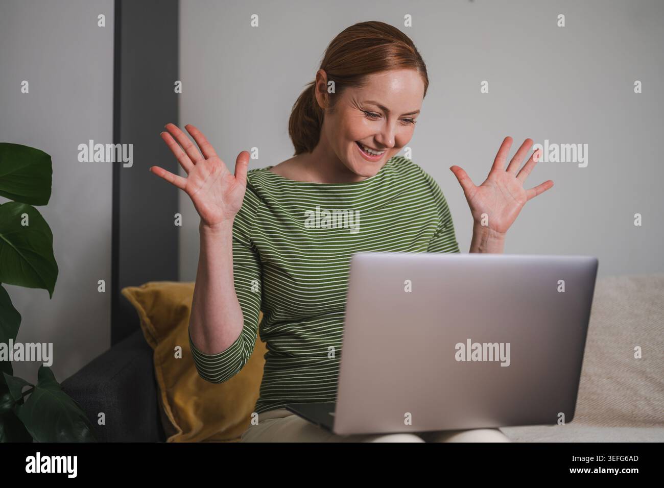 Successful remote work, happy woman celebrating at laptop Stock Photo