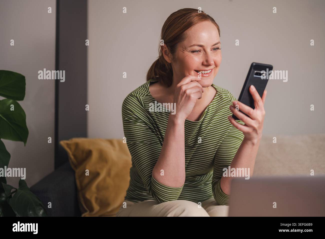 Successful online communication concept, smiling woman using phone Stock Photo