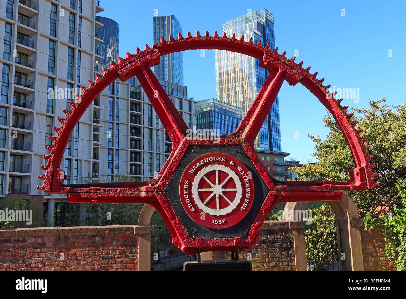 Red Grocers’ Warehouse waterways wheel at Castlefield near the viaducts, Manchester, marking canal and industrial heritage. Stock Photo