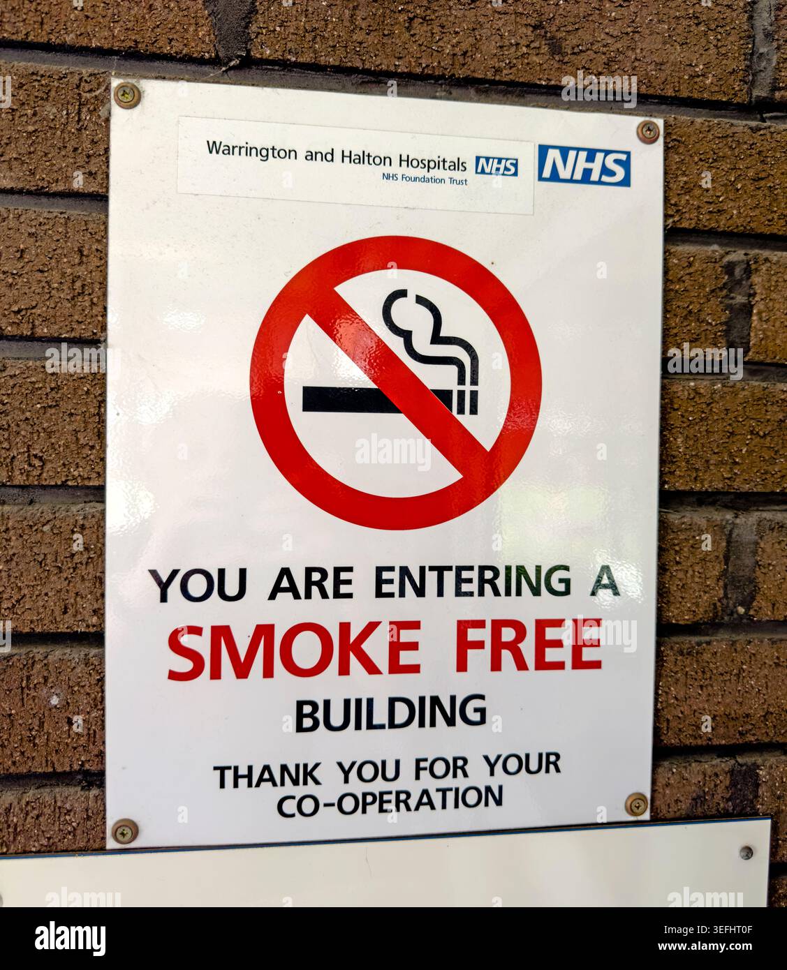 No-smoking notice at an NHS hospital building, promoting a smoke-free environment for patients, visitors and staff. Stock Photo