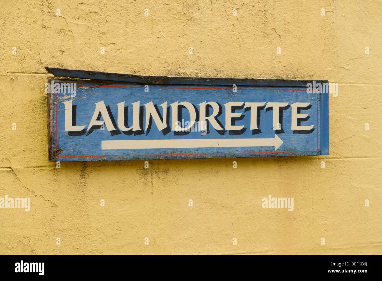 Old directional 'Laundrette' sign on a wall. Stock Photo