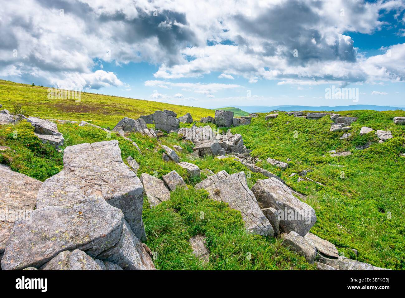 mountainous carpathian landscape during summertime. boulders and rock formations surrounded grassy hills. picture of a sunny forenoon with clouds on t Stock Photo