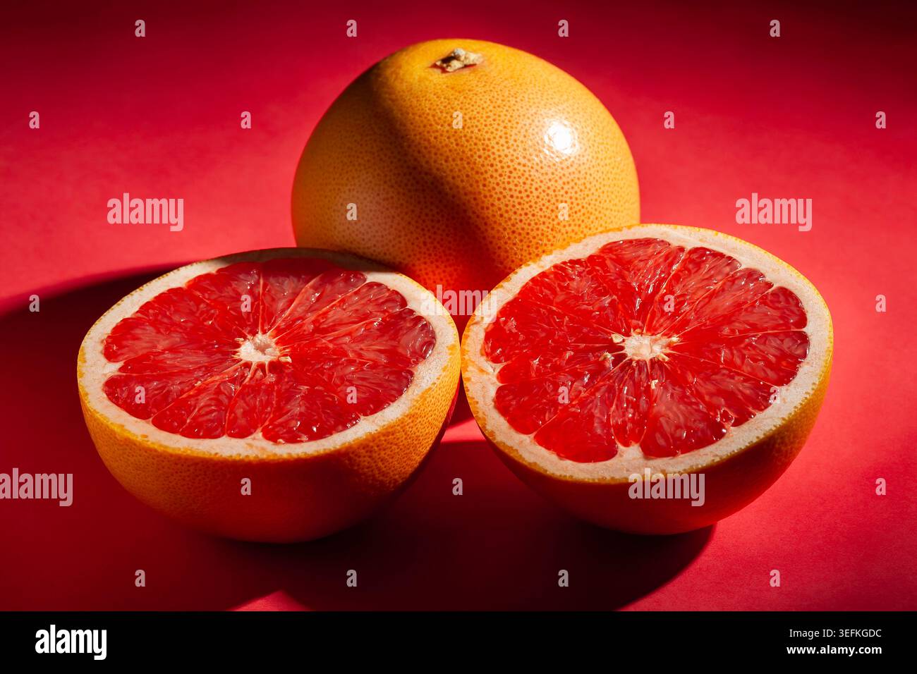 sliced grapefruit on red background Stock Photo
