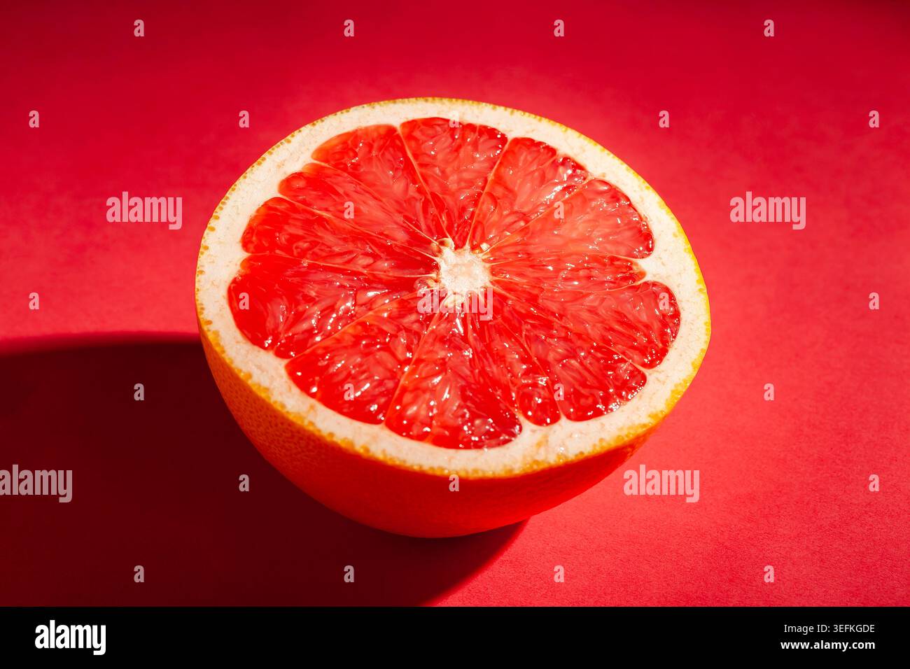 sliced grapefruit on red background Stock Photo