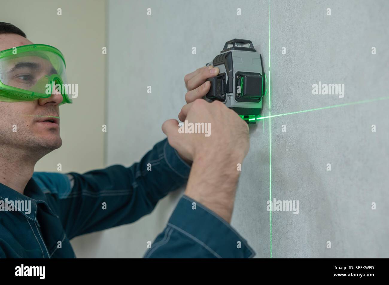 A man measures distance with a laser level.  Stock Photo