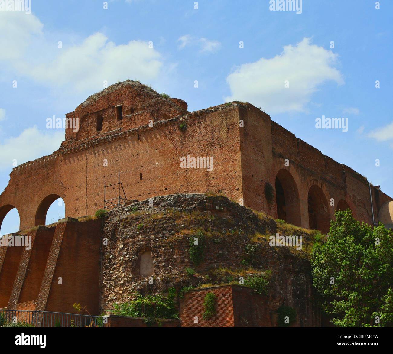Ancient Roman brick ruins and arched structure under a blue sky in Rome ...