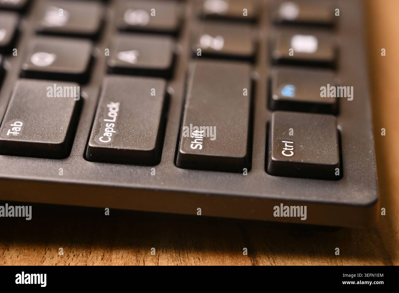 Side Angled Macro Close-Up Black Computer Keyboard Highlighting Shift Key on Blurred Tech Backgrounds Stock Photo