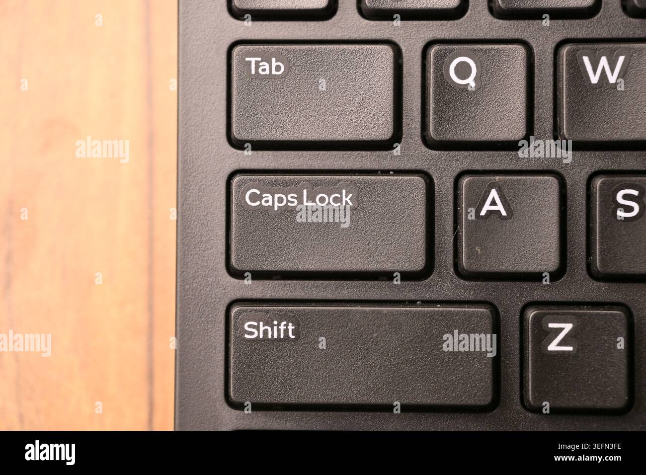 Black Computer Keyboard Macro Shot Highlighting Caps Lock Key with Soft Blurred Backgrounds Top View Stock Photo