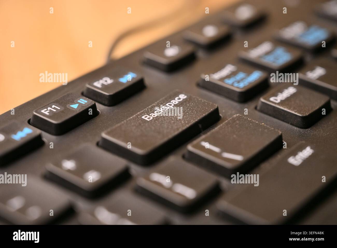 Macro Angled Top View Black Computer Keyboard Highlighting Backspace Key on Blurred Tech Backgrounds Stock Photo