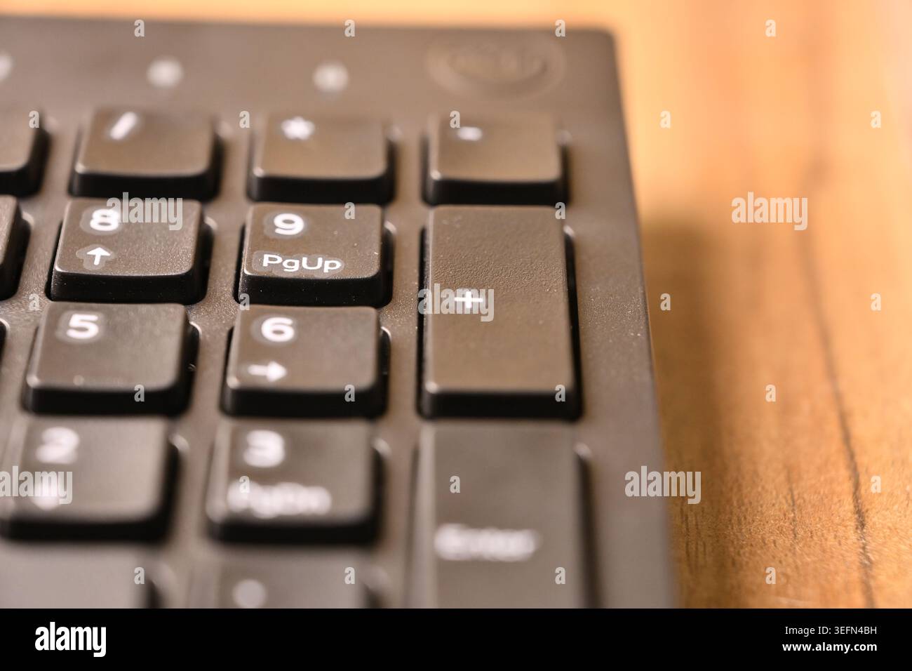 Angled Top View Macro Close-Up Black Computer Keyboard Highlighting Plus Key on Numeric Keypad on Blurred Tech Backgrounds Stock Photo