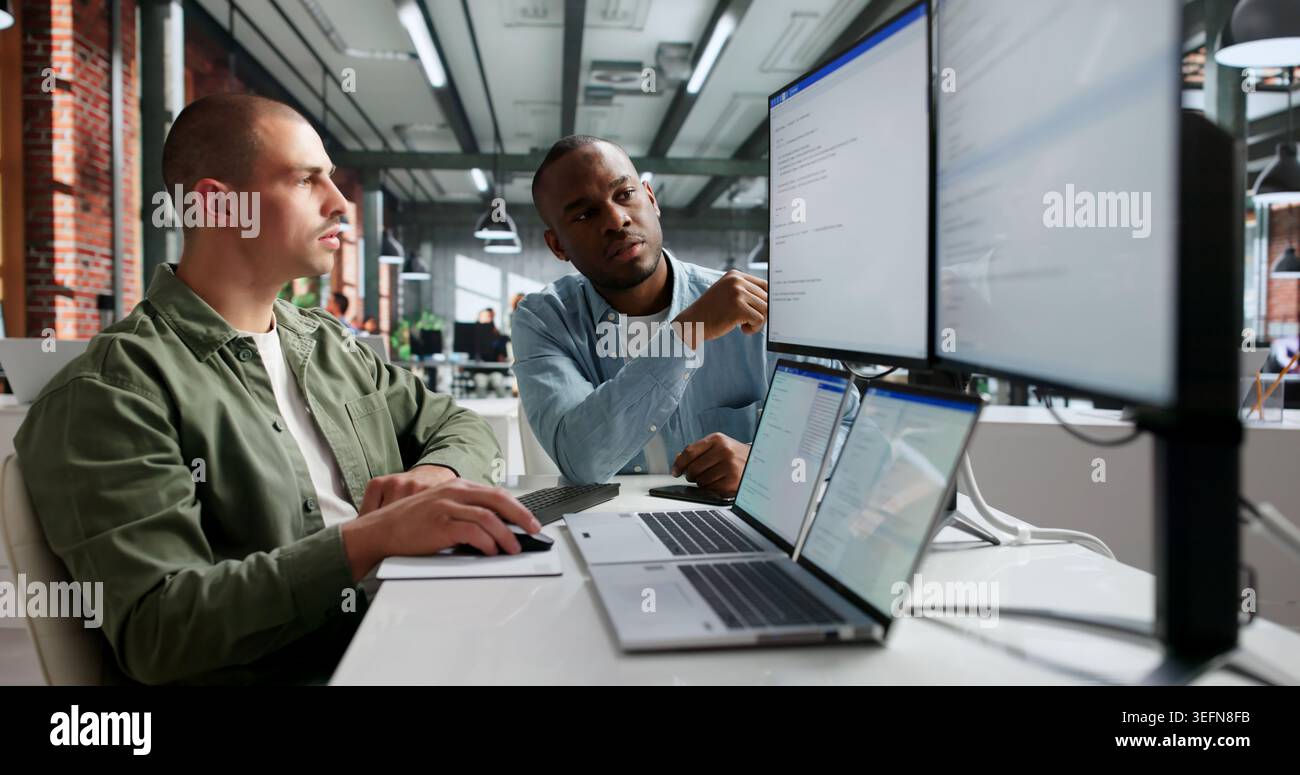 Two Young Software Engineers Working Together On Secure Web Coding. Stock Photo