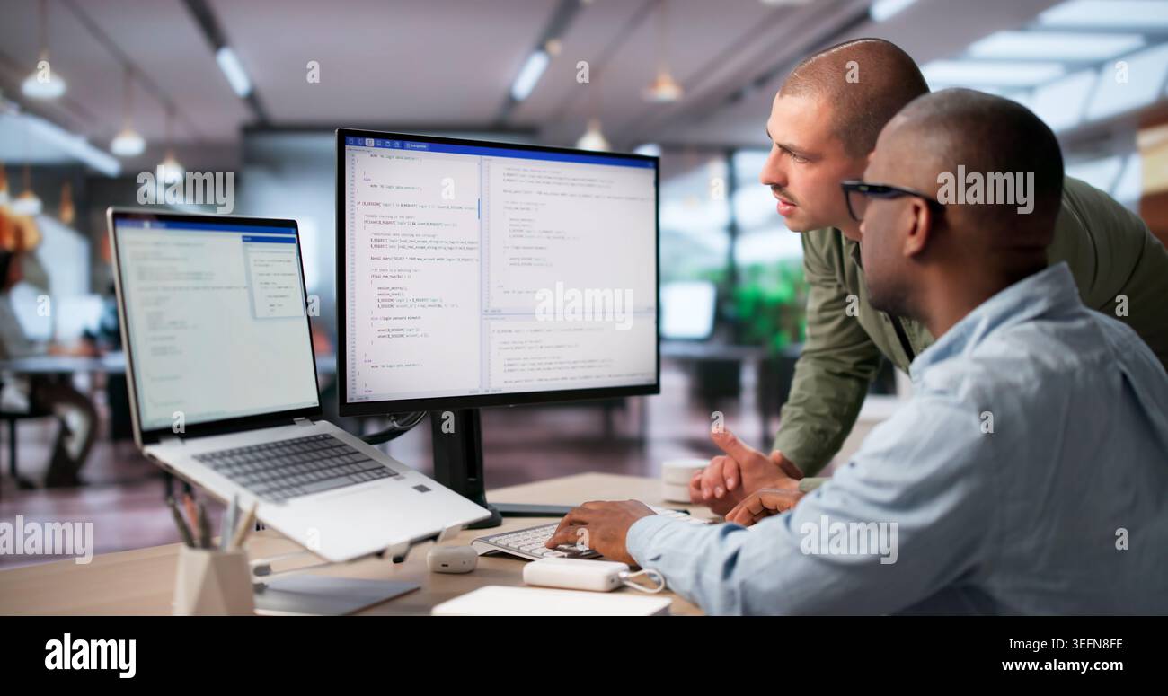 Two Software Engineers Collaborate On Secure Coding For Cloud Systems. Stock Photo