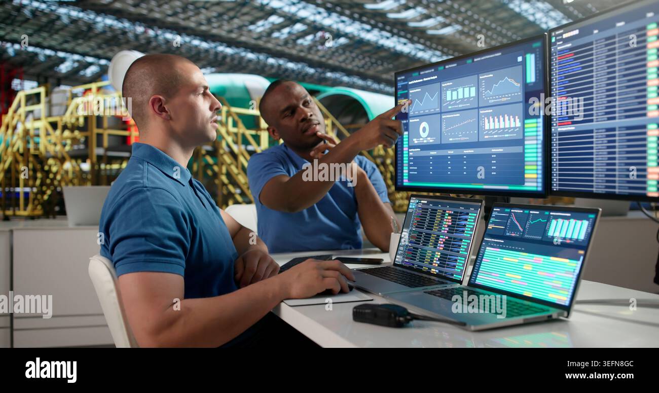Young Aerospace Engineer Is Using SCADA Software To Check Airplane Engines. Stock Photo