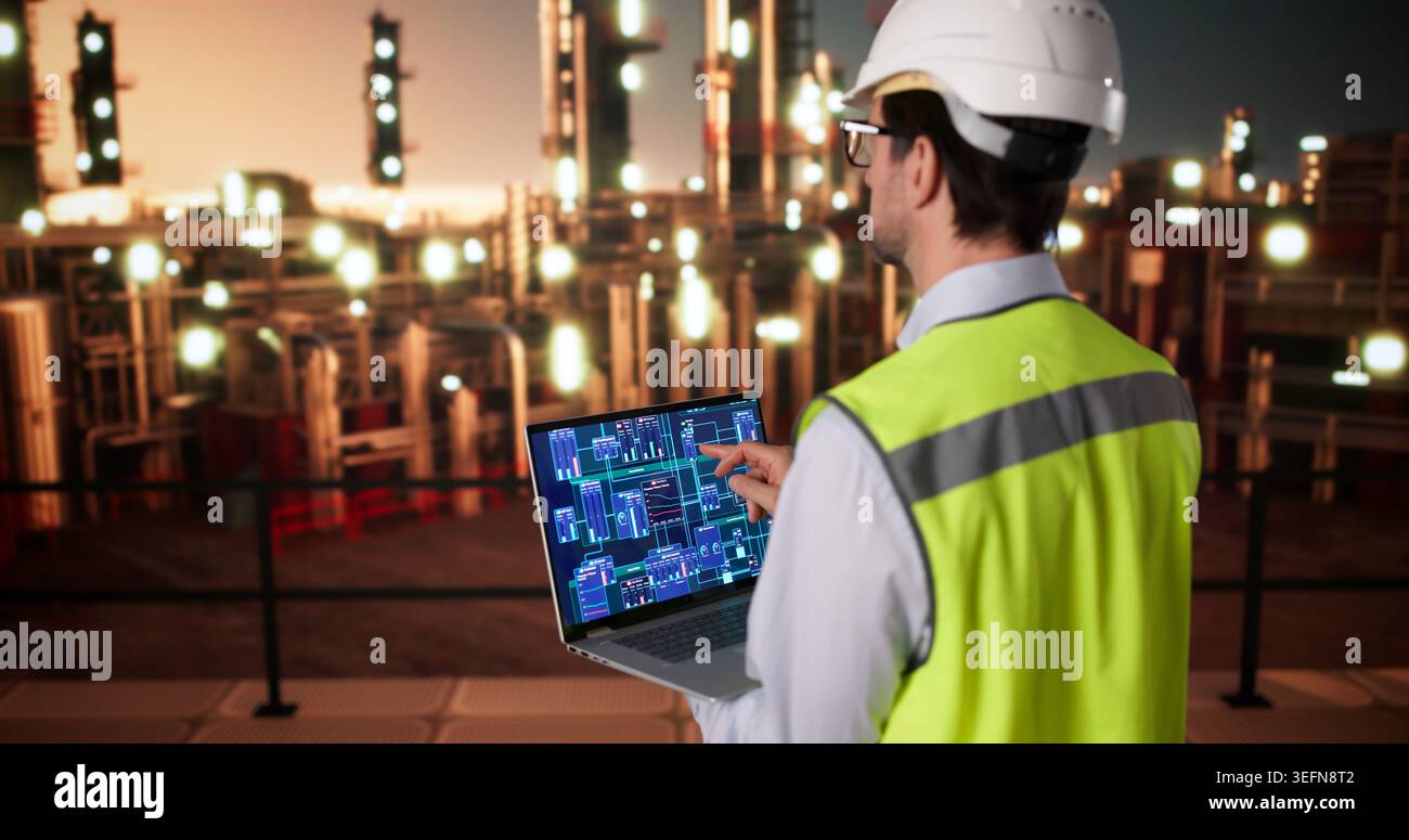 Engineer Monitors Refinery Data On Laptop While Inspecting Industrial Pipelines. Stock Photo