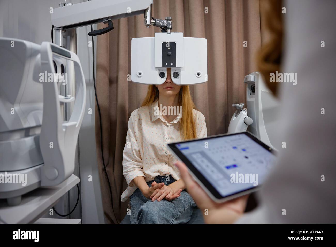 Visual Check Up Female patient having detailed eye checkup. Young woman receiving ...