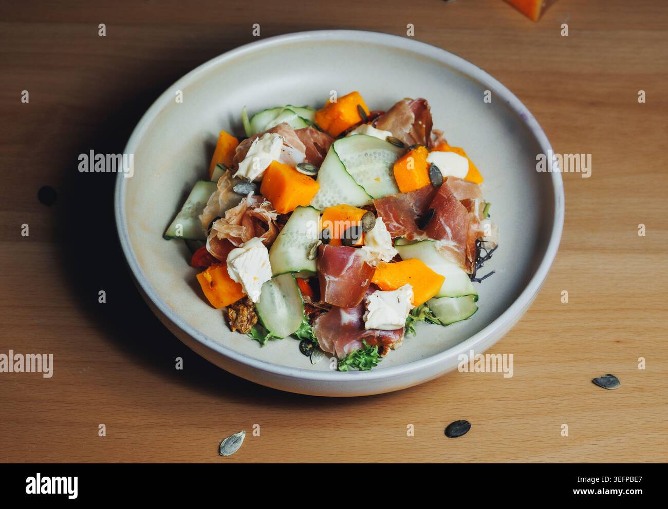 Plump, juicy melons, crisp cucumber, and lean meat slices on a plate Stock Photo