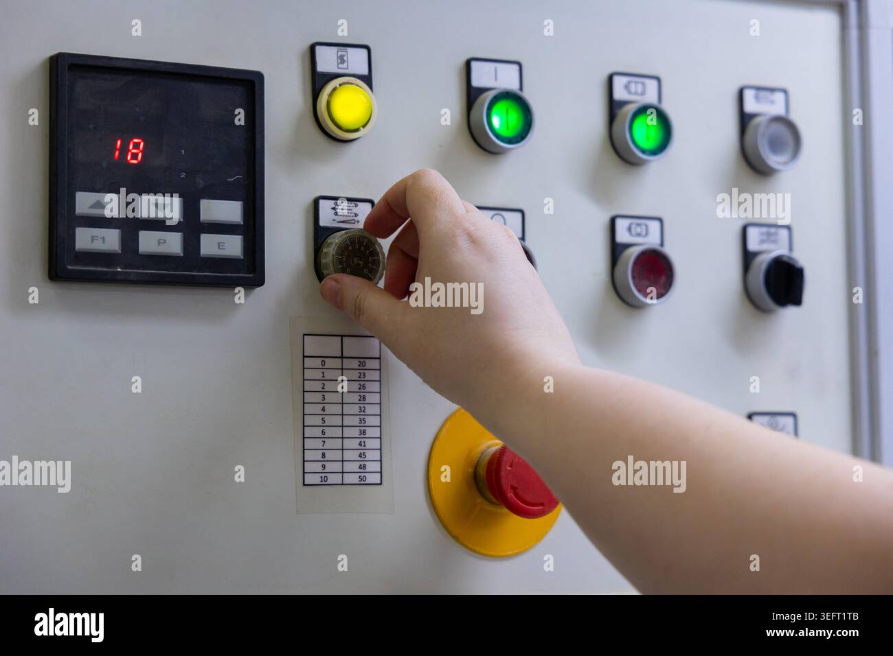 Operator Adjusting Industrial Machine Control Panel Stock Photo