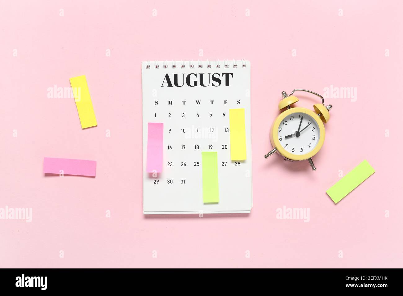 Alarm clock with calendar and sticky notes on pink background. Time management concept Stock Photo
