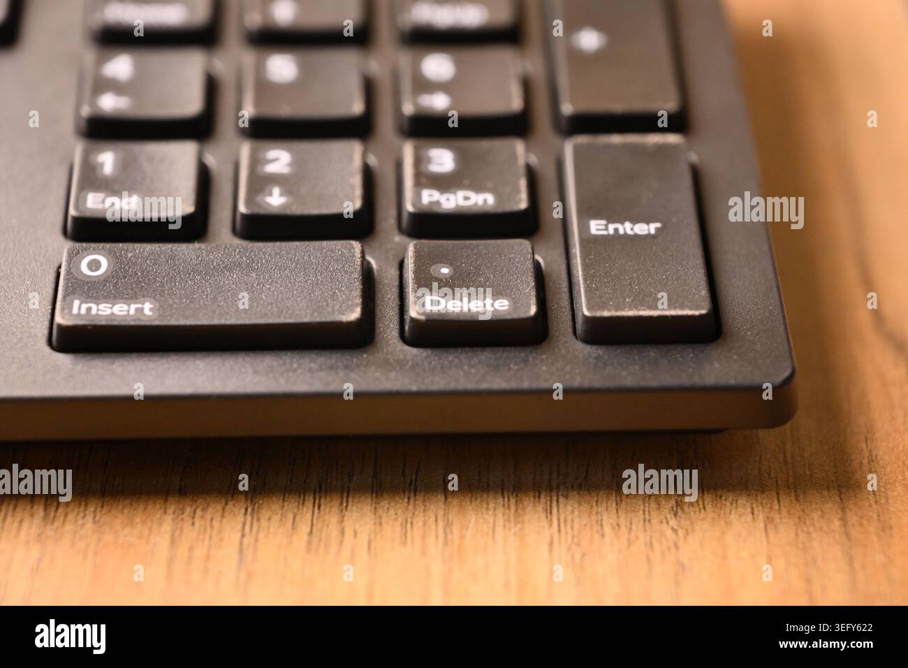 Black Computer Keyboard Macro Shot Highlighting Delete Key on Numeric Keypad Angled Top View with Soft Blurred Backgrounds Stock Photo