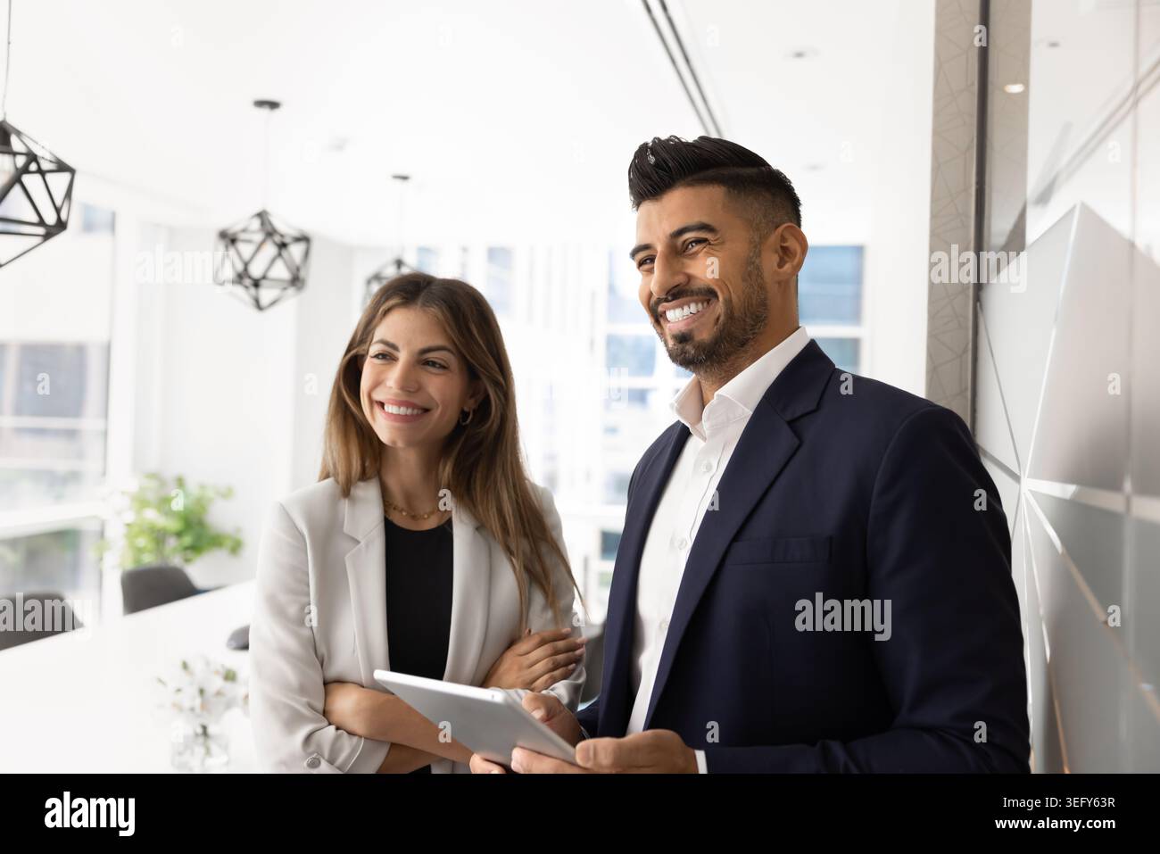 Two professionals smiling, feel satisfied with teamwork results and workflow Stock Photo