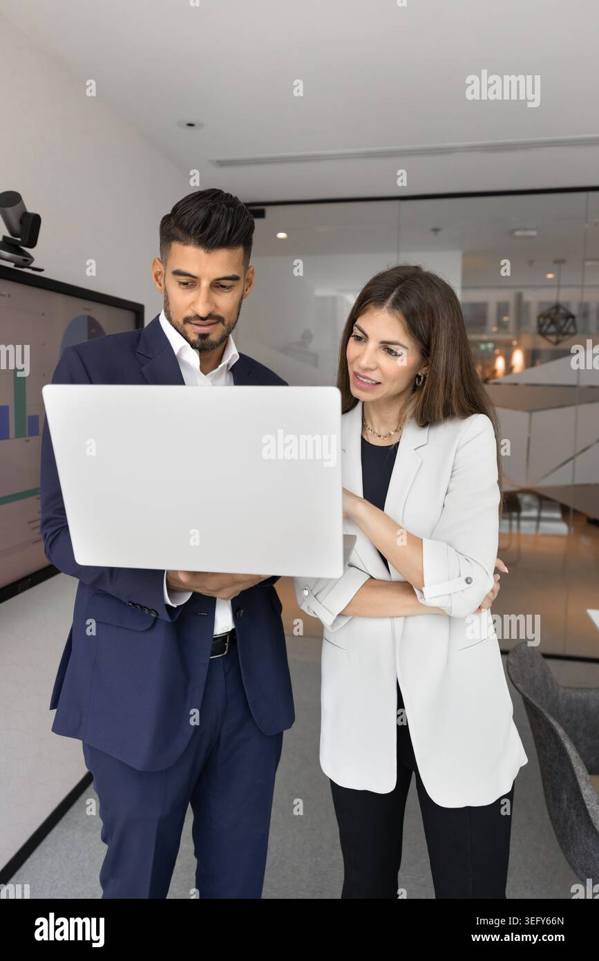 Two business colleagues discussing data on laptop Stock Photo
