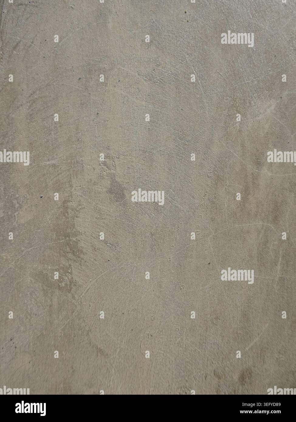 Macro of rough concrete surface with gray and beige mottling, granular speckles, and subtle imperfections, ideal as an abstract industrial background Stock Photo