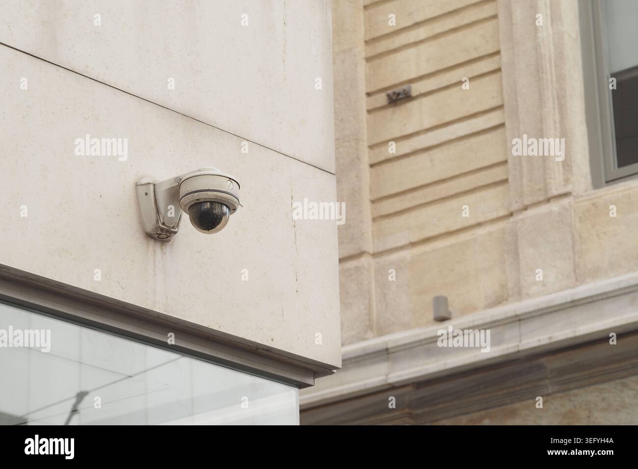 Security camera mounted on a building in a city area Stock Photo