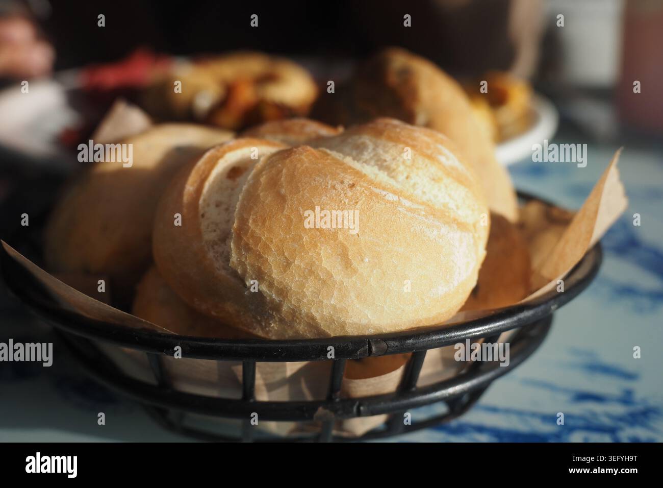 Fresh rolls in a basket on a dining table Stock Photo