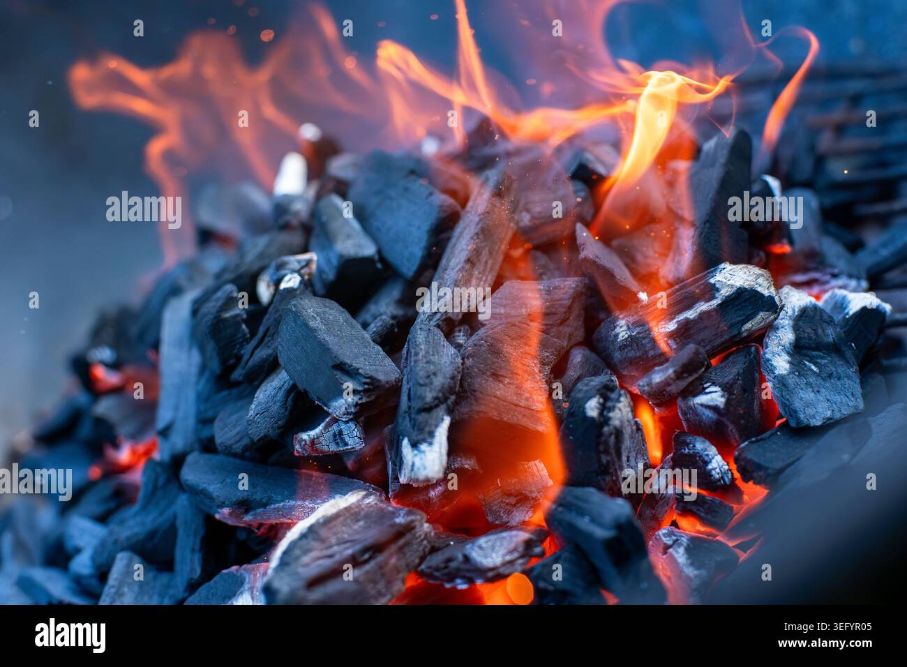 Dynamic Summer Barbecue Fire Close-Up, Glowing Coals with Flames Stock Photo