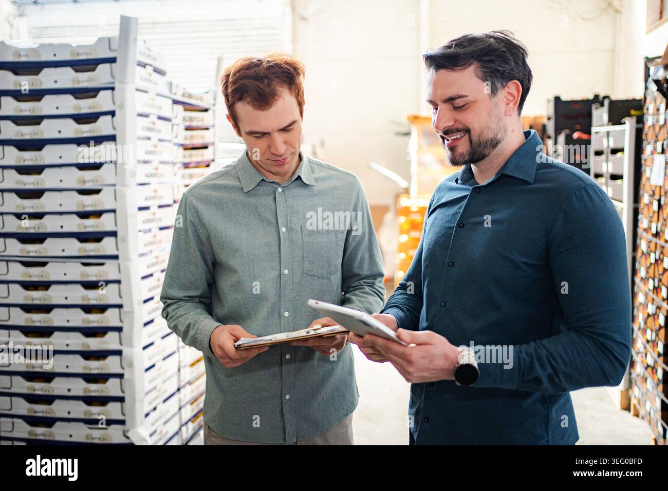 Warehouse managers collaborating on inventory using digital tablet Stock Photo