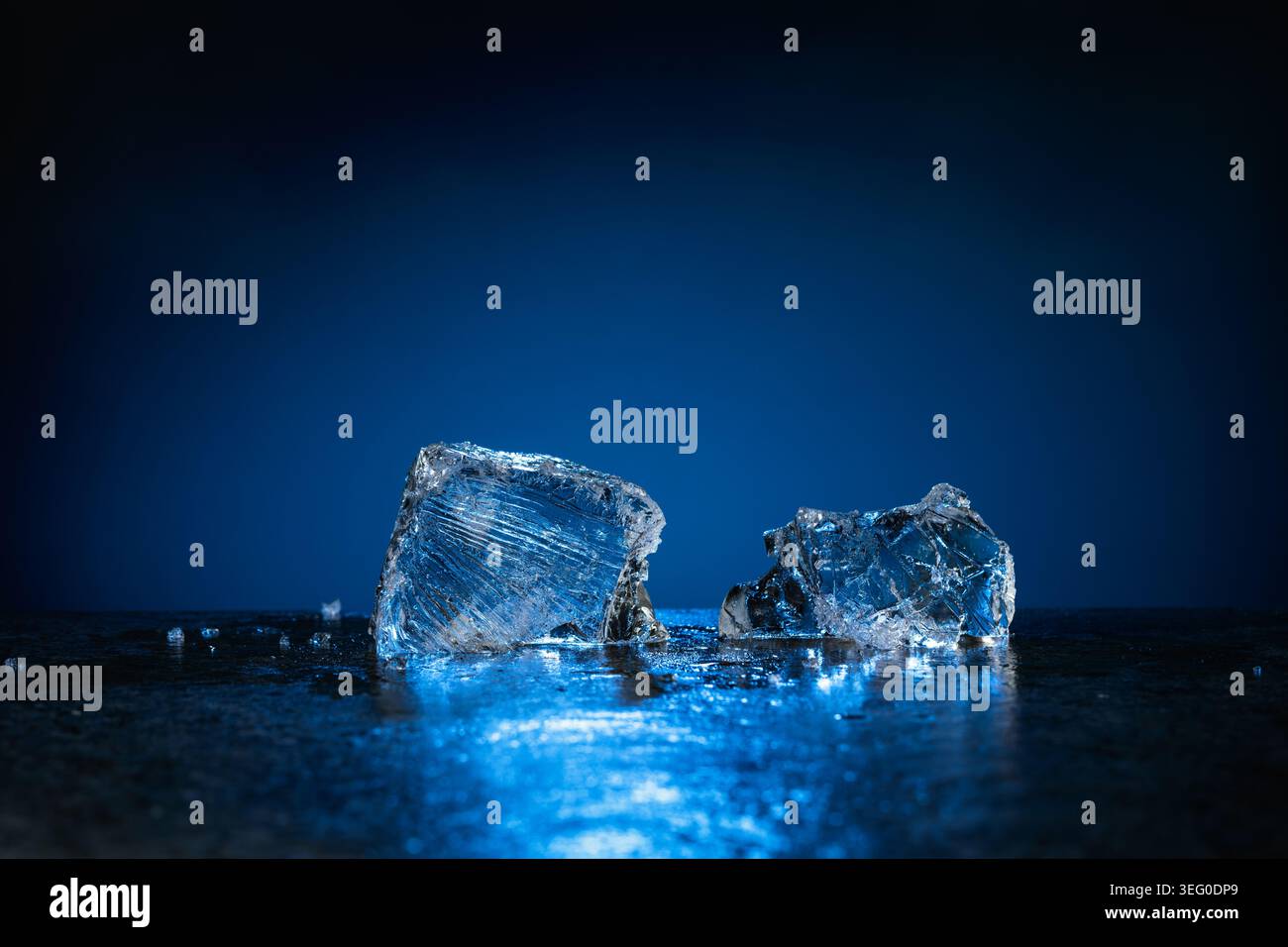 Broken ice with blue backlight on a dark background. Copy space. Stock Photo