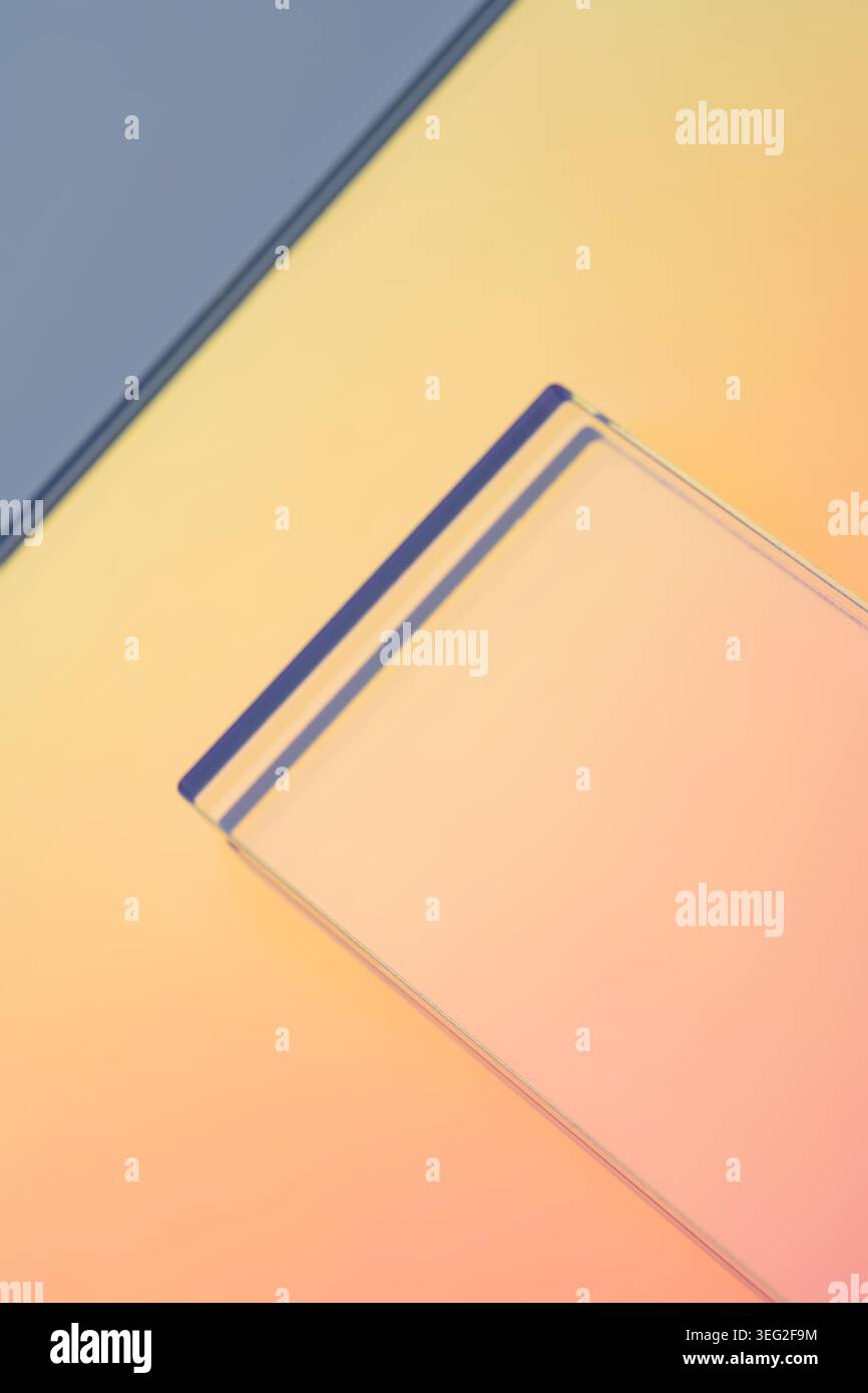 Minimal abstract scene with a translucent glass rectangle on a soft neon pastel gradient background, clean geometric lines, warm light. Stock Photo