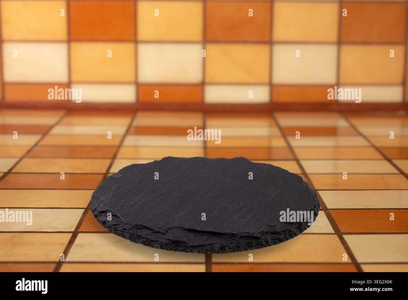 Round black stone slab on Rectangular ceramic tiles counter and backsplash mockup, soft focus perspective close up, empty design Stock Photo