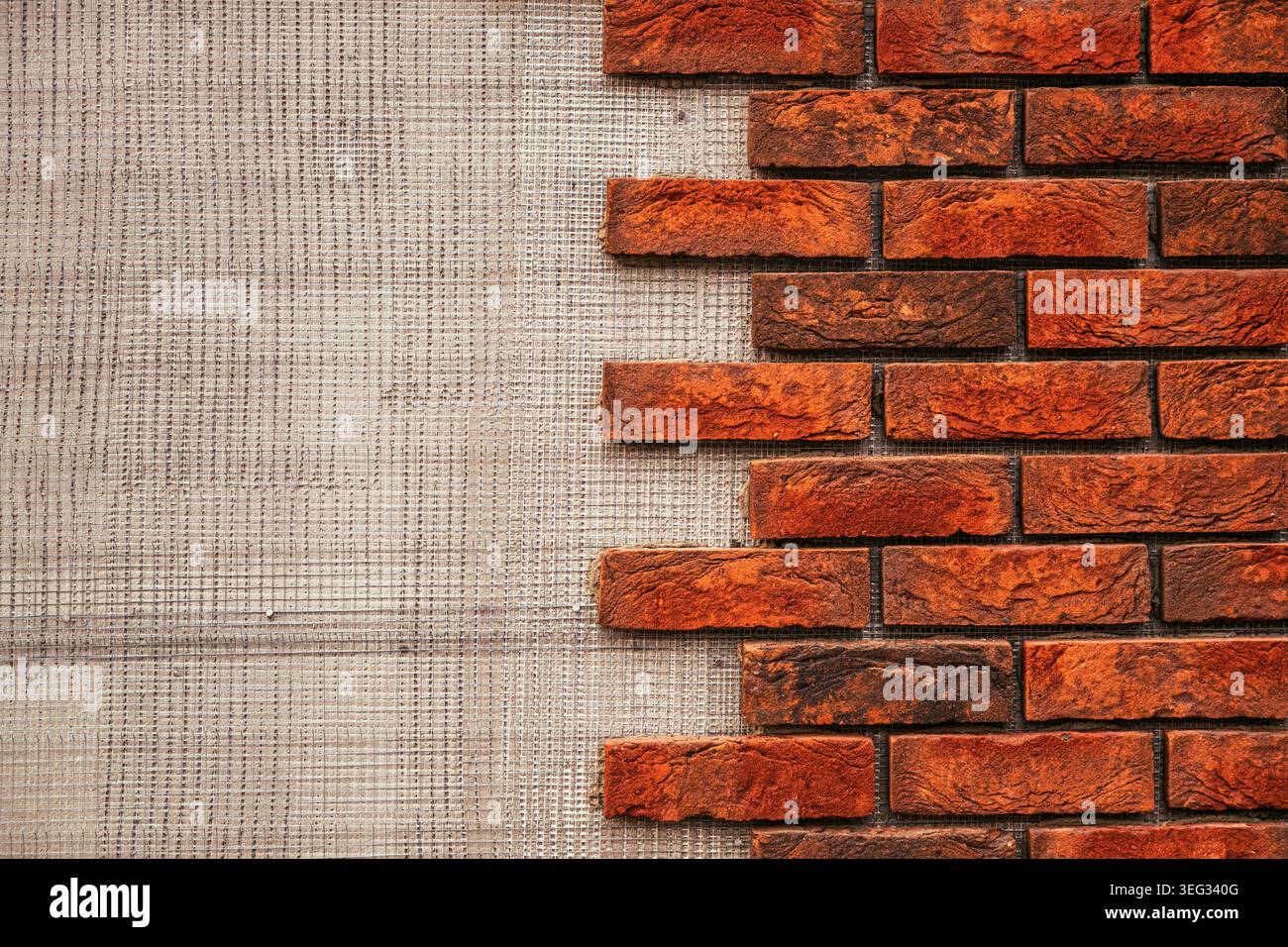 Red brick wall texture partially exposed over plaster background for construction and design Stock Photo
