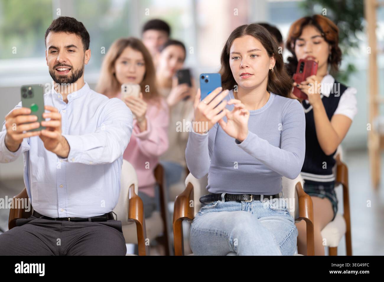 Students using mobile phones to scan QR code during interactive lesson Stock Photo