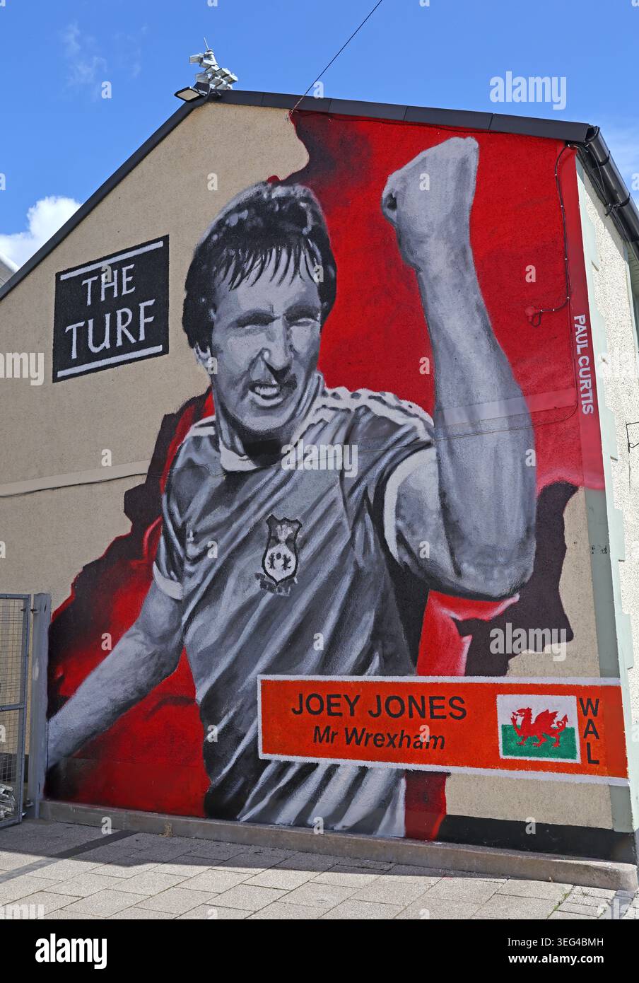 Large Paul Curtis mural celebrating Wrexham football legend Joey Jones on the exterior wall of The Turf pub beside Cae Ras. Stock Photo