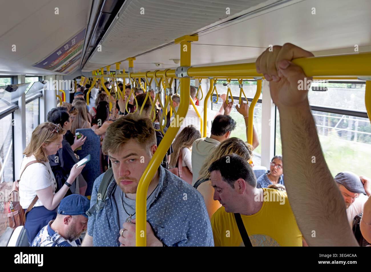 Crowded Manchester Metrolink tram in the city centre, commuters standing on Bee Network light rail linked with Andy Burnham Stock Photo