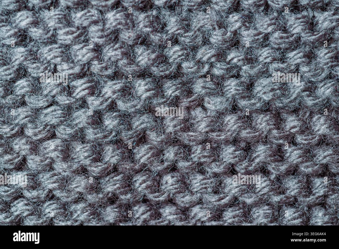 Detailed texture of a woolen textile with visible yarn loops and fibers, showcasing a cozy and warm material Stock Photo