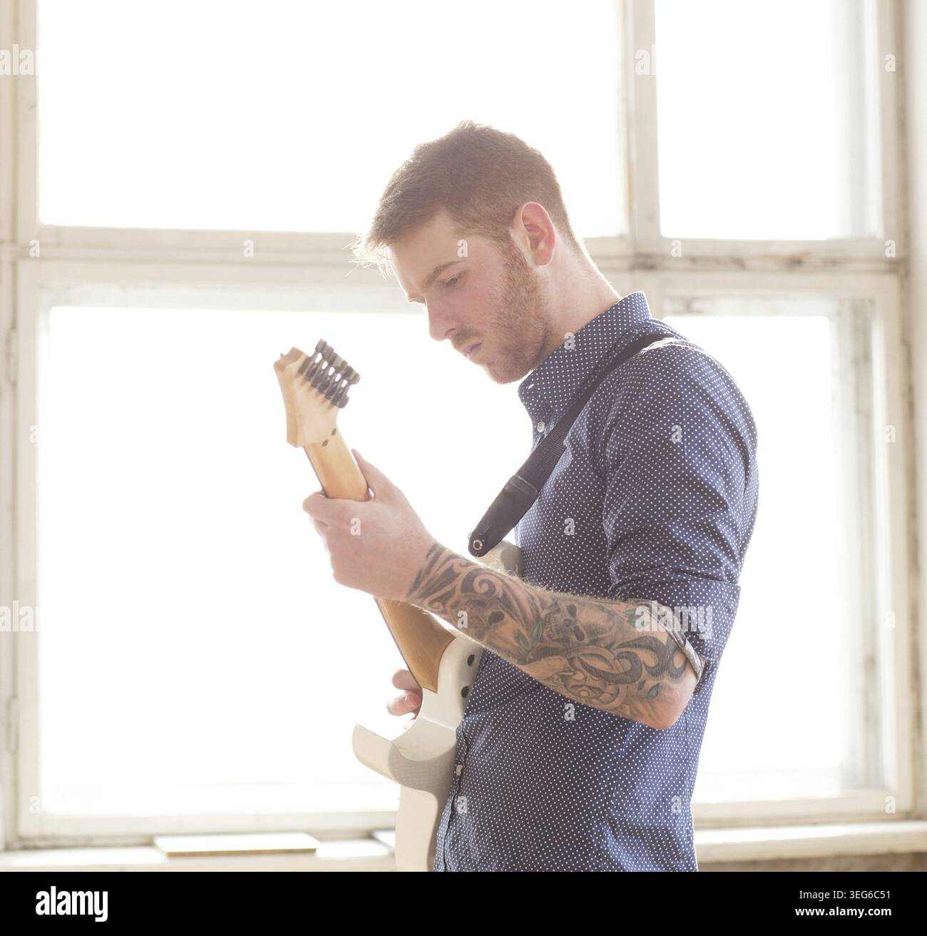 Handsome man playing on guitar Stock Photo