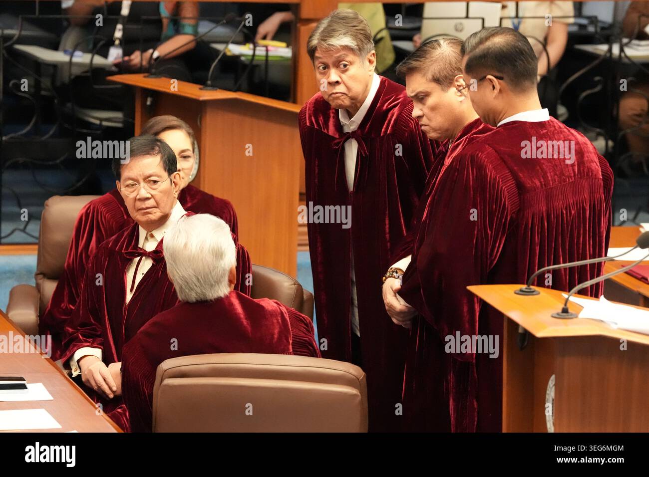 Philippine senators wearing robes talk before they convene as an ...